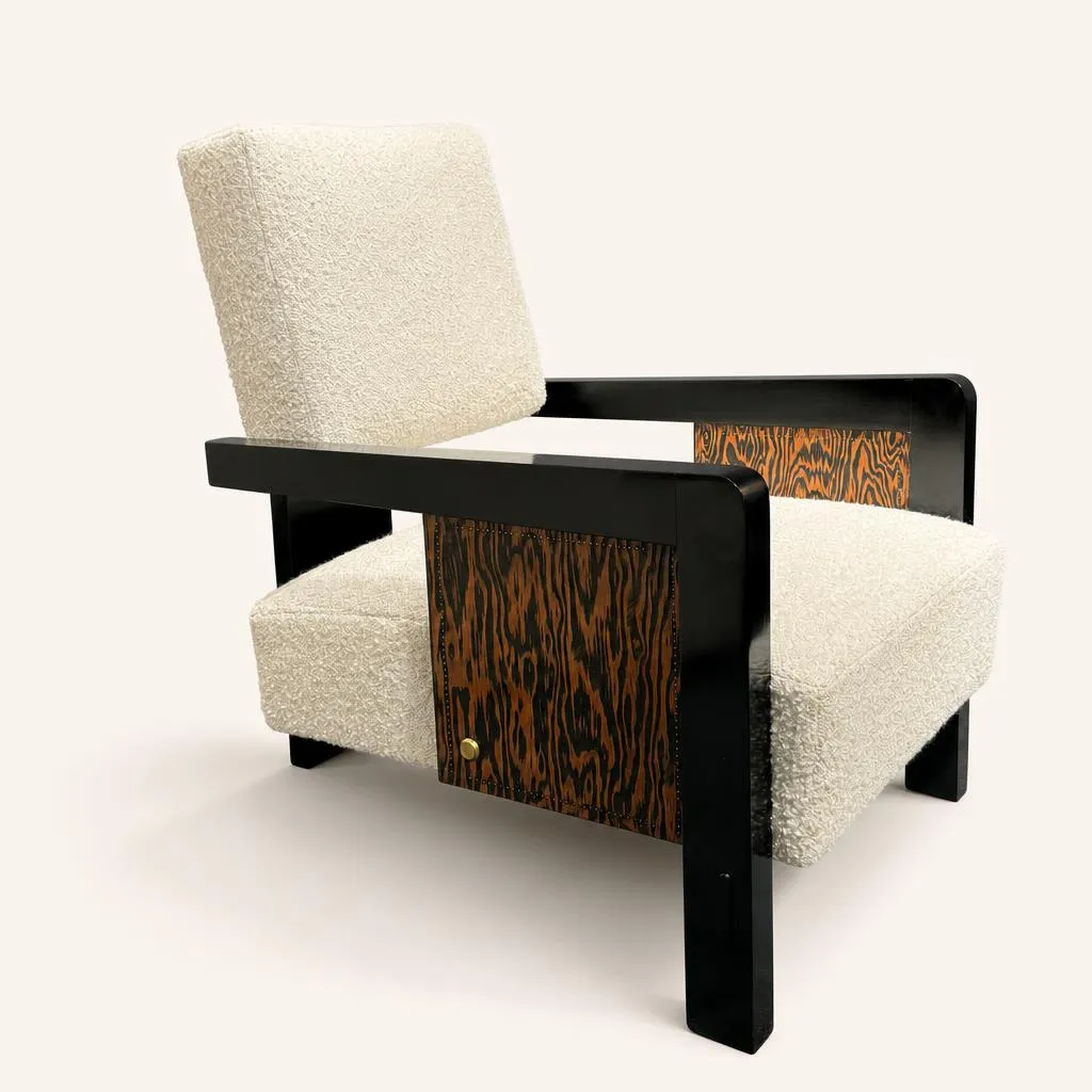Fauteuil en pin d'Oregon clouté et acajou teinté La structure se compose d'un puissant montant dorsal vertical et d'accoudoirs géométriques formant un angle droit en acajou teinté noir. L'assise profonde et le dossier sont recouverts d'un tissu bouclé écru texturé.  

Le pin d’Orégon est d’abord travaillé à la brosse métallique afin de créer du relief, il est ensuite teinté en foncé puis poncé, la teinte reste dans les parties creuses alors que les crêtes retrouvent leur couleur naturelle tirant sur l’orange. Par cette méthode originale, André Sornay obtient des décors bicolores où le brun foncé et l’orange se côtoient en vagues longues et sinueuses presque magnétiques suivant le caprice du veinage.