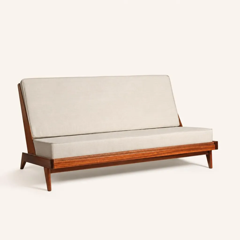Banquette en acajou massif. Conçue « toute face », cette pièce présente un dos en acajou au veinage vertical, lui permettant d'être disposée au centre d'un espace. La structure s'appuie sur un piètement fuselé et légèrement incliné qui prolonge la ligne dynamique des montants arrière. L'assise et le dossier inclinés sont munis d'un tissu de teinte claire couleur crème.

André Sornay élabore un système de montage rapide des meubles dont il dépose les différents brevets entre 1953 et 1955. Ce brevet, la « tigette Sornay » s’avère révolutionnaire. Ce procédé fonde tout le système du mobilier dit en « kit » utilisé de nos jours. Le montage du meuble se borne à l’assemblage d’un cadre arrière muni d’inserts filetés destinés à recevoir les tigettes et d’un cadre avant. Les écrous sont laissés apparents en façade. 