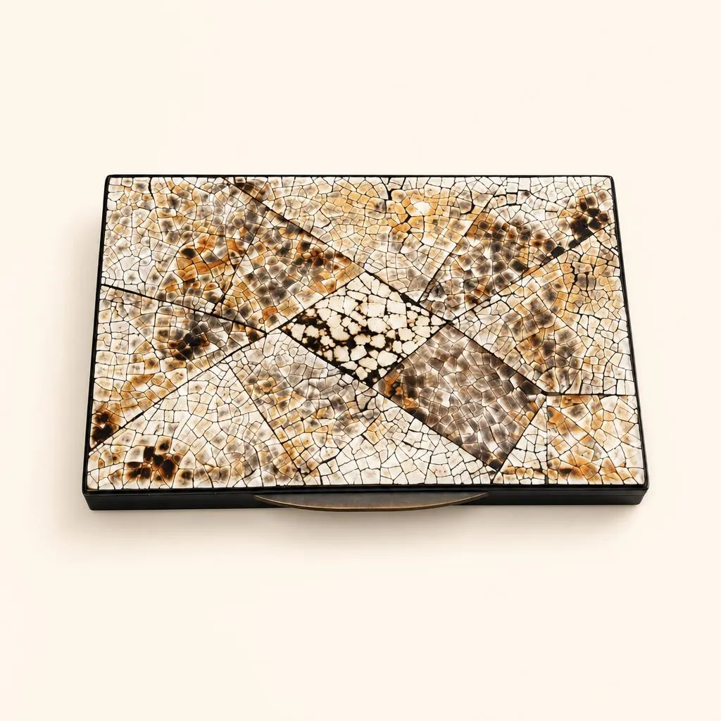 Petite boîte de forme rectangulaire en laque de Chine noire. Le couvercle présente une composition géométrique compartimentée en mosaïque de coquille d'œuf incrustée et partiellement nuancée au feu. L'intérieur est entièrement habillé d'une laque poudrée d'or. 

Signé « Jean Dunand ».