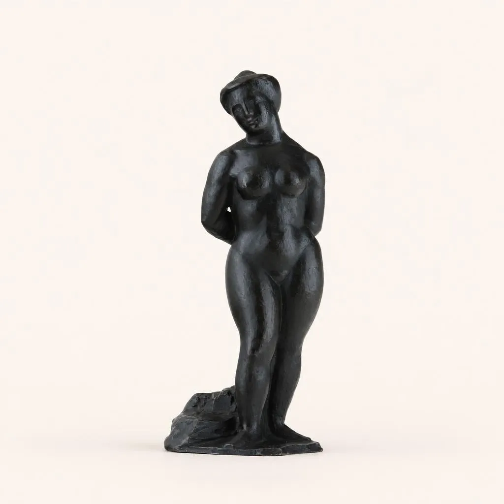 Réalisée en bronze fondu au sable (probablement par Florentin Godard), cette épreuve à patine sombre représente un nu féminin debout, saisi dans un léger “contrapposto”, les mains jointes derrière le dos et les cheveux relevés. Le corps se caractérise par une architecture de volumes opulents et généreux, alliant des lignes doucement arrondies à une géométrisation synthétique de la forme. La figure repose sur un petit socle terrassé intégré en bronze.

Non signée. Marquée sous la base à l'intérieur du cachet « KH » et du numéro « IIII » en relief ; porte l'étiquette de la Galerie Flechtheim (Berlin / Düsseldorf).

Exposition :
• “Manolo”, Galerie Simon (Paris), Galerie Alfred Flechtheim (Berlin et Düsseldorf), Galerie Flechtheim & Kahnweiler (Francfort), 1929, p. 10, n° 9 (Stehende nackte Frau, 1912).

Bibliographie :
• Catalogue d'exposition “Manuel Martinez Hugué dit Manolo,” Galerie Louise Leiris, Paris, 1961, n° 17 (Nu debout, bronze, h. 24 cm).
• Montserrat Blanch, “Manolo, sculptures, peintures, dessins”, Éditions Cercle d'Art, 1974, reproduit p. 30, n° 18 (épreuve conservée au Museum of Modern Art, New York).