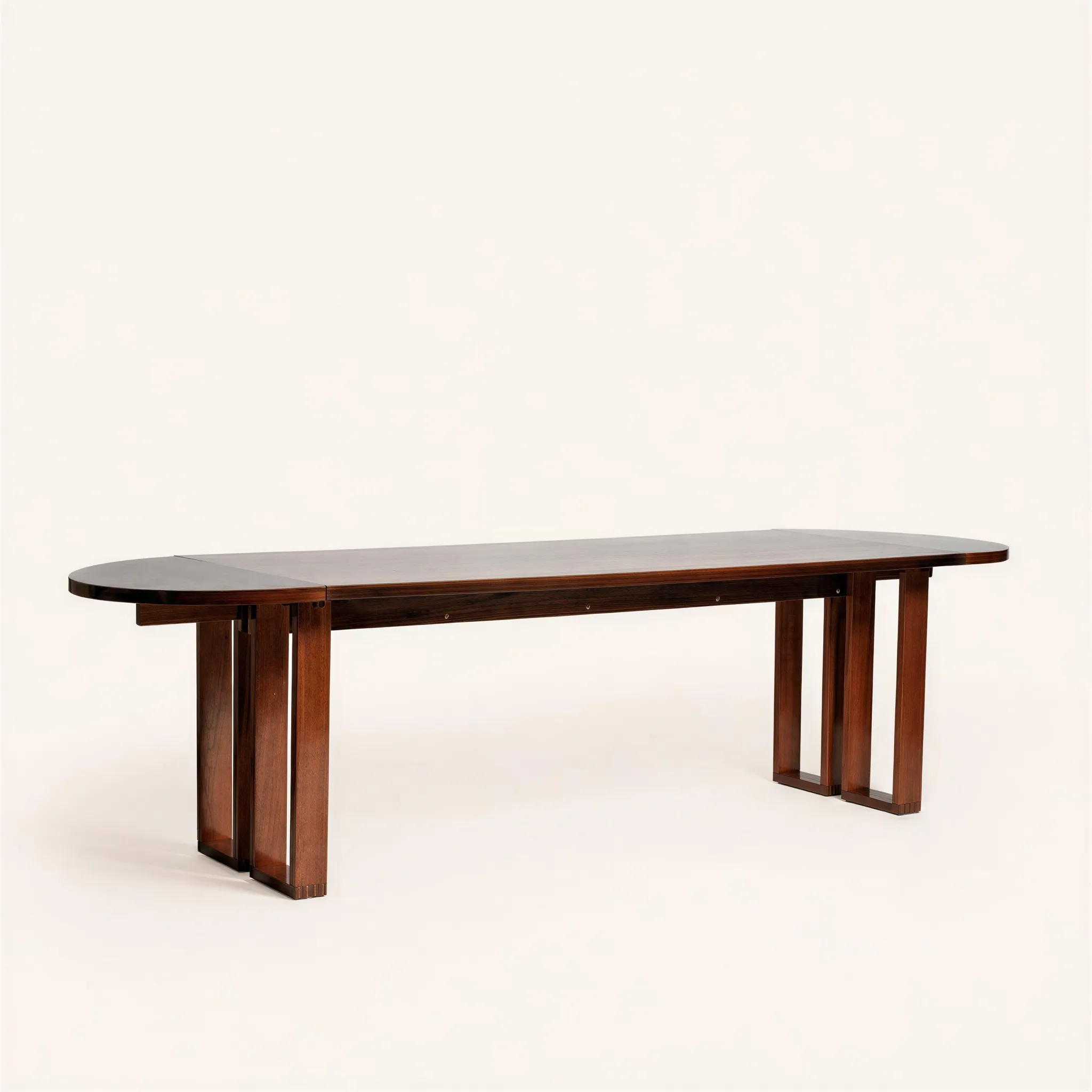 Table-bureau de forme rectangulaire. Son plateau en palissandre est flanqué de deux allonges demi-lunes rabattables, permettant de moduler sa longueur de 198 cm à 282 cm. L'ensemble de la structure et le piètement architectural ajouré, composé de montants verticaux rectilignes, sont réalisés en acajou.

André Sornay élabore un système de montage rapide des meubles dont il dépose les différents brevets entre 1953 et 1955. Ce brevet, la « tigette Sornay » s’avère révolutionnaire. Ce procédé fonde tout le système du mobilier dit en « kit » utilisé de nos jours. Le montage du meuble se borne à l’assemblage d’un cadre arrière muni d’inserts filetés destinés à recevoir les tigettes et d’un cadre avant. Les écrous sont laissés apparents en façade. 