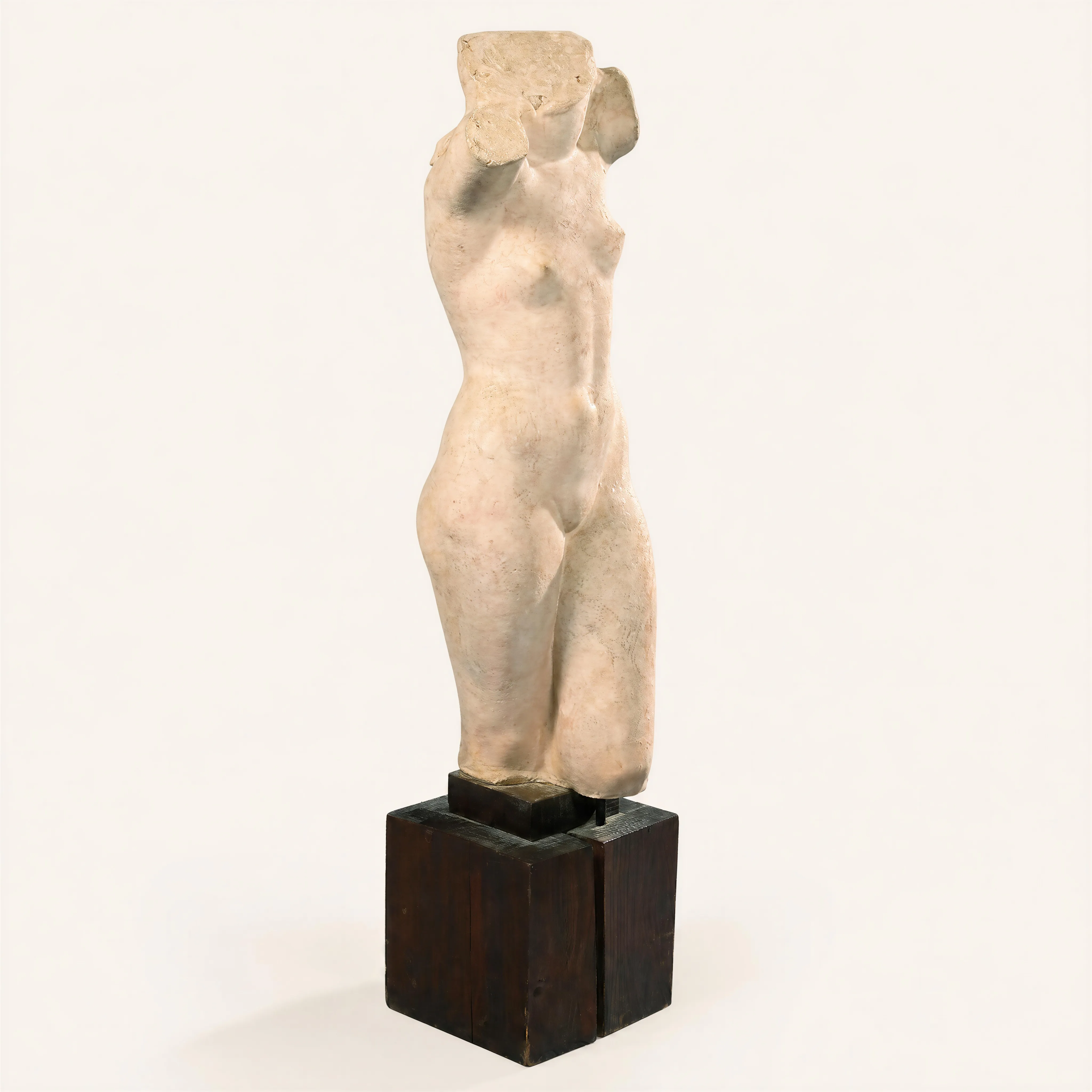 A fragmentary sculpture in the round depicting the nude torso of a young woman. Crafted from chamotte clay, which gives the surface a raw, textured appearance, the piece is styled in an antique manner, headless, armless, and cut at mid-thigh. The sinuous line of the waist and a slight contrapposto impart a natural, flowing movement to the body. The sculpture rests on its original, slightly stepped cubic fir wood base. 
Signed in hollow with the monogram "L.I." and dated 1920.
Literature:
• Adolphe Basler, "Jewish Artists, Indenbaum", Edition “Le Triangle”, Paris, model reproduced under no. 1.  
• “La Renaissance”, March 1932, article by Waldemar George "Formes et lumière. Variations on Léon Indenbaum", model reproduced p. 64.  
A stone version of this model was exhibited at the 13th Salon d'Automne at the Grand Palais des Champs-Elysées in 1920 (catalog no. 1132). 

