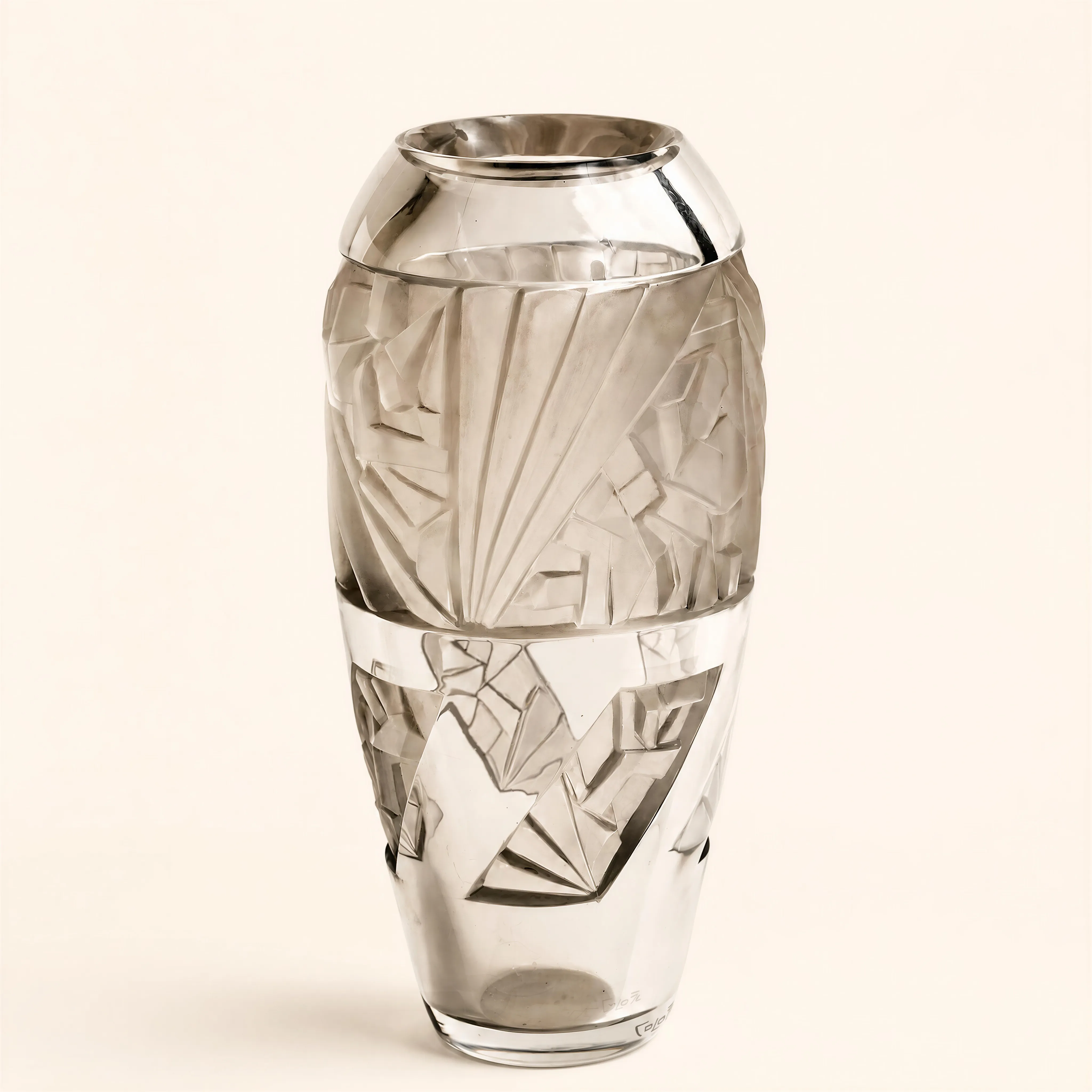 Vase de forme ovoïde en cristal soufflé, s'amincissant vers la base et se terminant par un col court rentrant aux parois biseautées et polies. Les finitions de la surface extérieure alternent entre des zones dépolies (aspect satiné) et des parties transparentes polies à l'outil.  
Le corps de l'objet présente un décor sculpté en fort relief composé de motifs géométriques d'inspiration cubiste. La section supérieure comporte des structures en escalier imbriquées et des motifs d'éventails stylisés dépolis. La section inférieure est taillée de larges facettes triangulaires prononcées, de pointes de diamants et de lignes brisées laissant apparaître le cristal transparent. 
Signature «Colotte » sur la base.