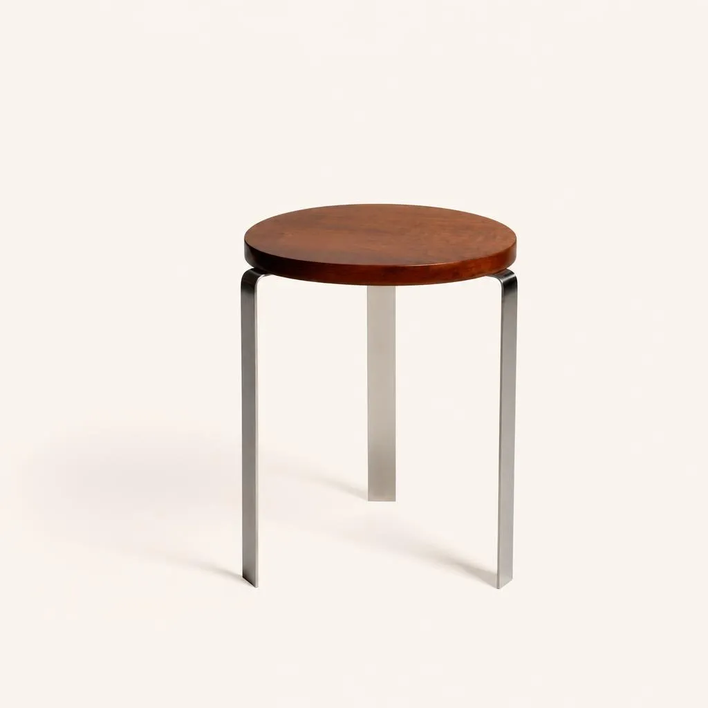 Table d'appoint en noyer massif et laiton nickelé. D'une grande pureté géométrique, la pièce se compose d'un épais plateau circulaire en noyer massif, soutenu par un piètement tripode formé de trois lames plates en laiton nickelé pliées à angle droit sous la ceinture. 

Réf. « André Sornay » par Thierry Roche p. 105.

Cette œuvre a été crée avant le brevet du cloutage donc avant 1932. Cette première production se caractérise par des meubles puissamment charpentés aux lignes simples, construits suivant les normes de l’ébénisterie traditionnelle. À cette époque, la production est essentiellement constituée de pièces uniques, plus rarement de meubles fabriqués à quelques exemplaires.