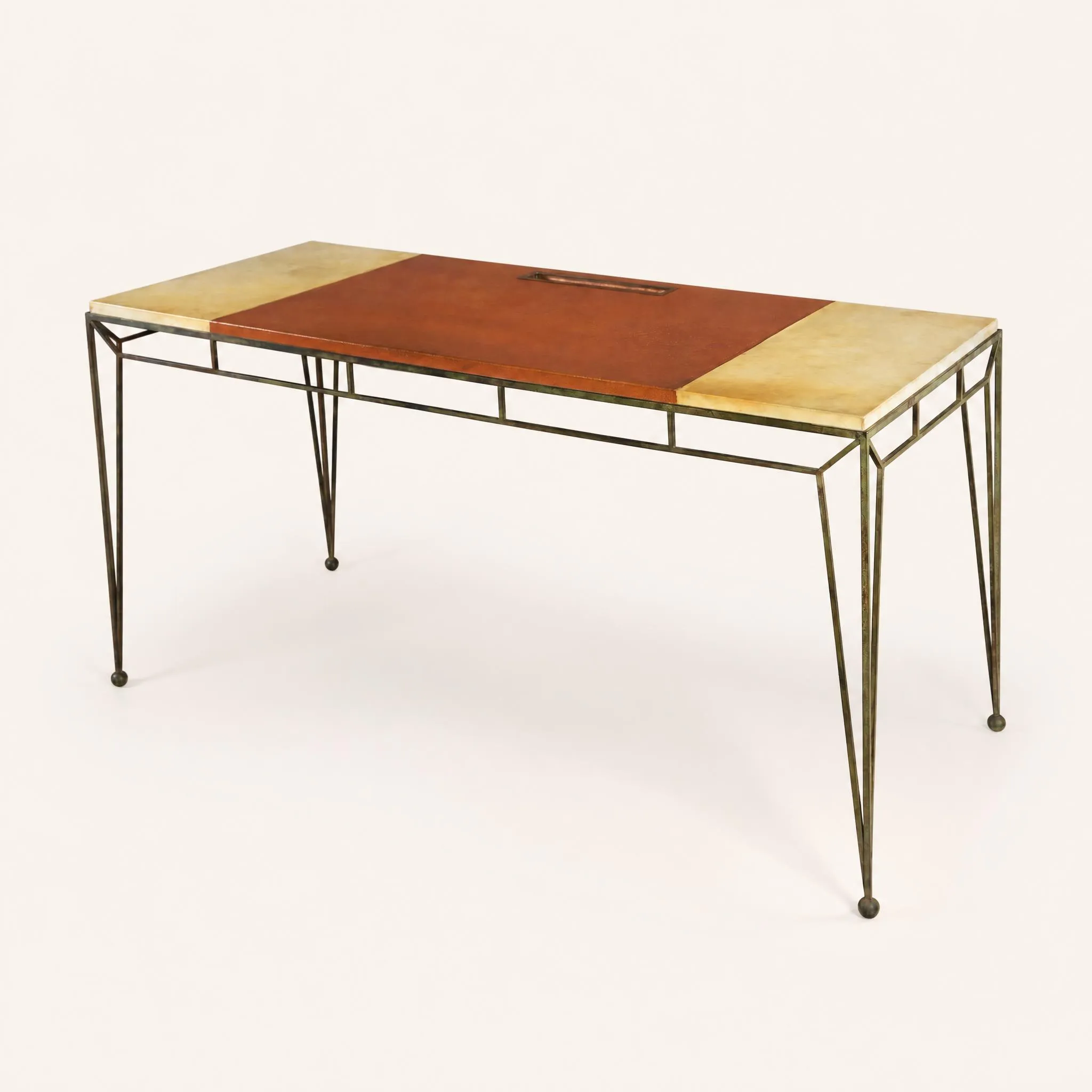 Table-bureau de forme rectangulaire reposant sur une structure géométrique en fer forgé à patine verte. Le piètement s'affine vers le bas et se termine par de petites boules. Le plateau se divise en trois sections horizontales : les deux extrémités sont gainées de parchemin clair, tandis que la partie centrale est recouverte de cuir fauve et intègre un plumier en métal encastré.  
Bibliographie : Y. Badetz, “Marc du Plantier”, Éditions Norma, Paris, 2010, modèles similaires reproduits p. 116, 117, 128 et 129.
Accompagné d'un certificat de M. Jean-Marc Maury.